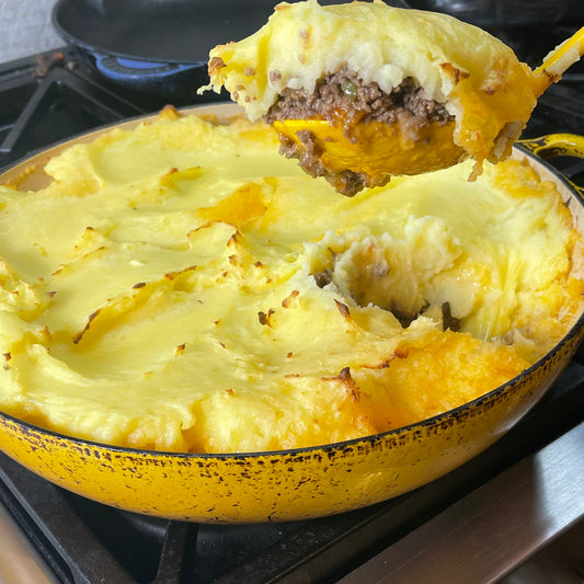 a spoon of cottage pie over a baking dish