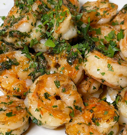 plate of shrimp garnished with chopped herbs