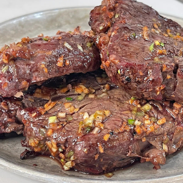 a plate with three pieces of grilled steak