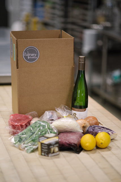 A box of cooking class ingredients and wine